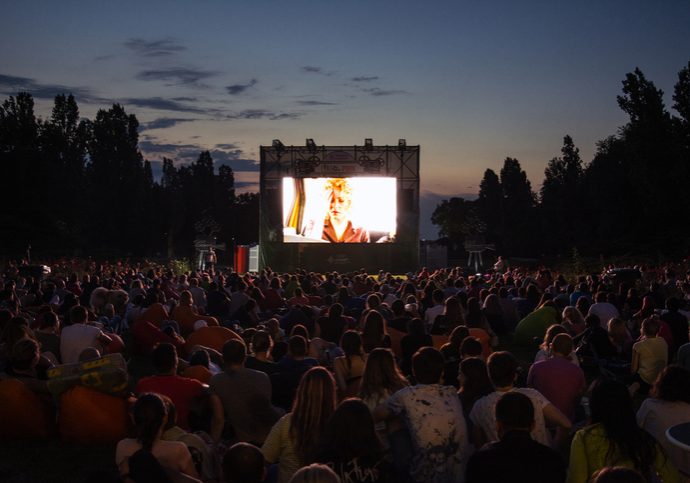 02 August 2018-Bucharest, Romania. People waiting and watching in the public park Herastrau for the movie to start on the projection screen of the open air cinema